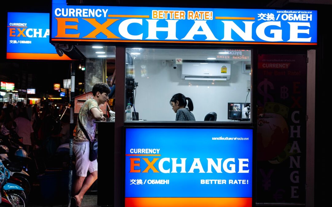 man in gray short standing near counter of currency exchange